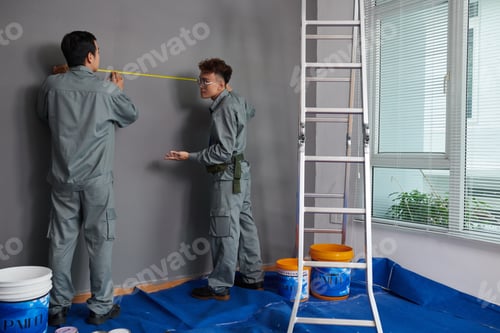 Preview: Team of builders measuring wall in house of clients