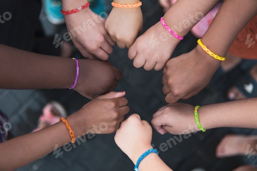 Preview: Multiethnic children hands together with rainbow bracelets