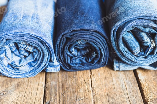 Preview: Jeans stacked on a wooden background