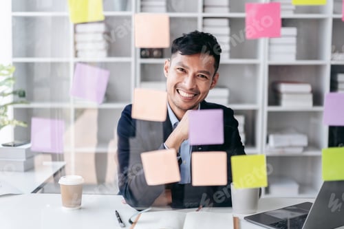 Preview: Businessman working and reading information in notes on the glass wall and thinking to analysis