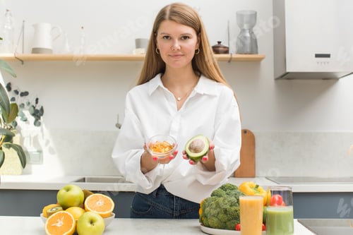 Visualização: A mulher segura cápsulas amarelas e de abacate com vitamina D e ômega-3. Saúde e dieta.
