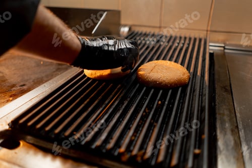 Preview: professional kitchen in the hotel restaurant chef puts burger buns on the grill