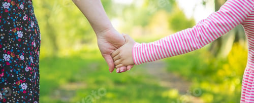 Preview: A child with his mother goes by the hand. Selective focus.