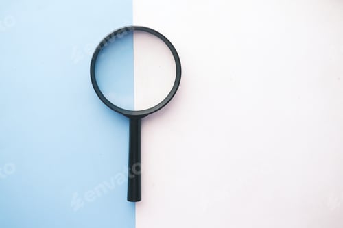Preview: open book and magnifying glass on table.