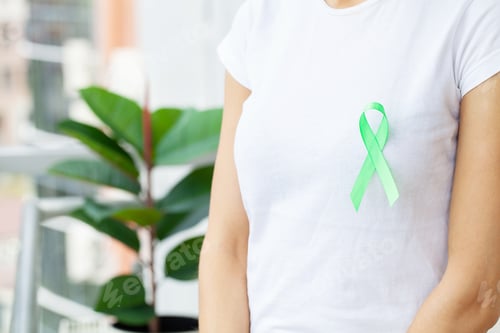 Preview: Green ribbon in hand as a symbol to awareness Lymphoma cancer