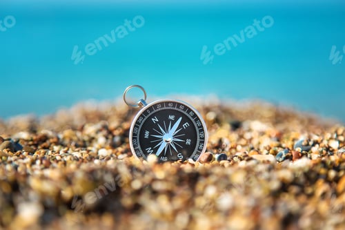 Compass on Sand Directing Towards the Ocean