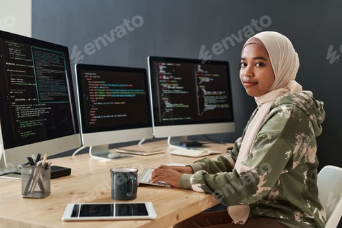 Preview: Young modern IT specialist in hijab and sweatshirt decoding information