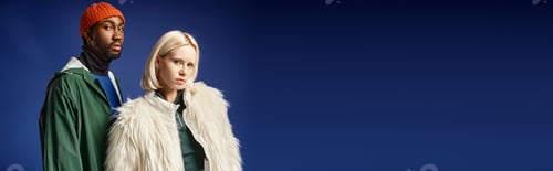 Preview: blonde woman posing with african american man in winter attire, banner of models on blue backdrop
