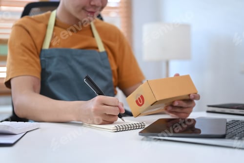 Preview: Young man online seller checking order before sending to customer.