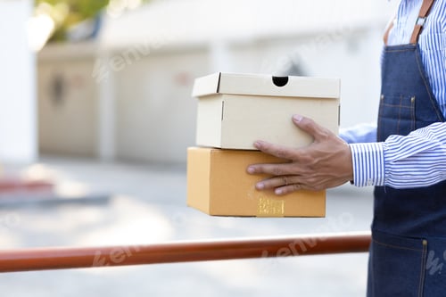 Preview: Close-up, the delivery man holding the parcel is handing it to the recipient.