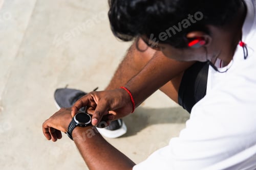 Vista previa: sport runner black man wear modern time smart watch he sitting resting