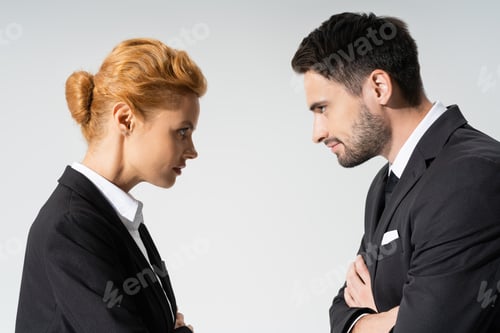 Preview: side view of distrustful business people looking at each other isolated on grey