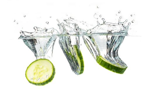 Preview: Sliced cucumber splashing water isolated on white background