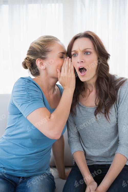 Preview: Shocked Woman Being Told A Secret By Her Friend And Sitting On The Sofa