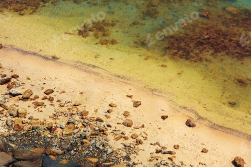 Preview: Close up of stones and clear water on the shore of a beach