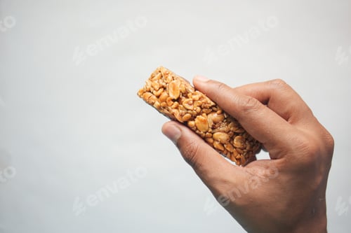 Preview: holding a Almond , Raisin and oat protein bar