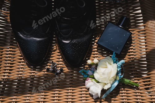 Preview: Top view of boutonniere, shoes, cufflinks and bow tie on the chair.