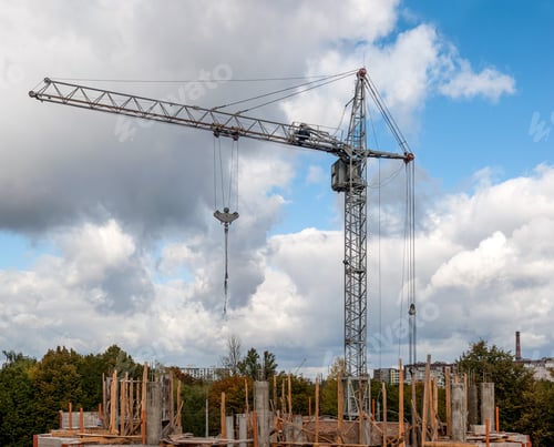Preview: tower crane on the construction of buildings made of monolith and brick