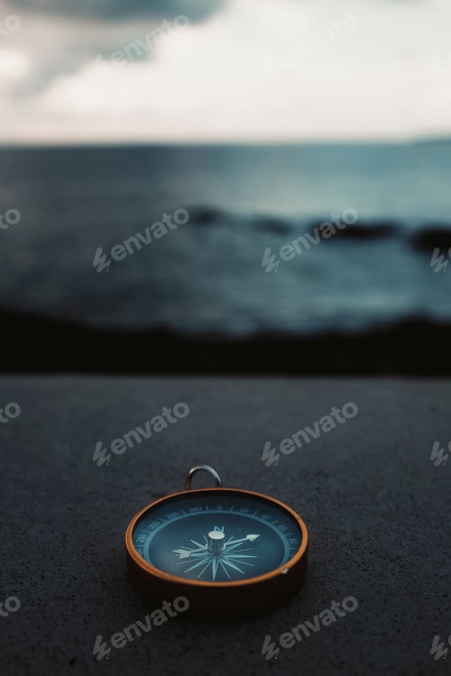Preview: Compass travel in front of water ocean landscape. Concept of lost and destination wanderlust