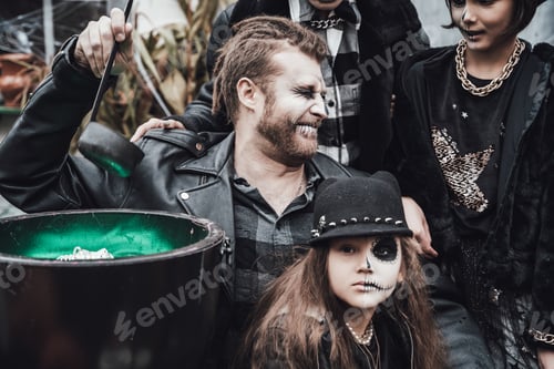 Preview: Scary family, mother, father, daughters celebrating halloween. Cauldron of potion.Terrifying black s