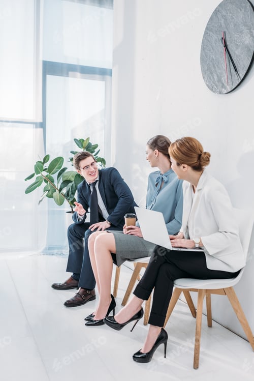 Preview: happy man in glasses talking with attractive women waiting job interview