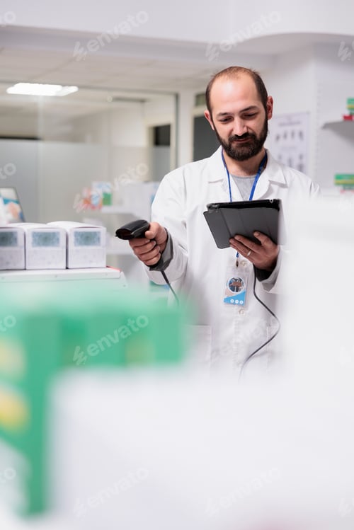 Preview: Pharmacist checking medication list on tablet computer while scanning pills packages bar code using