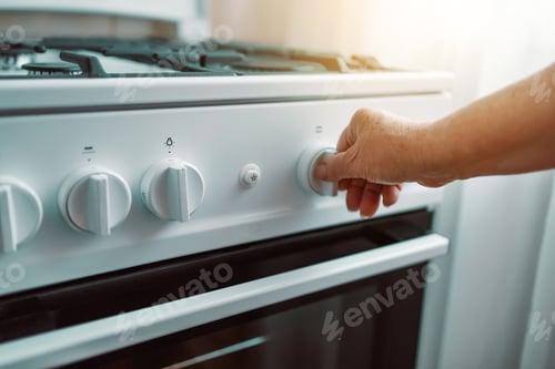 Preview: Woman hand regulates the temperature of new gas stove
