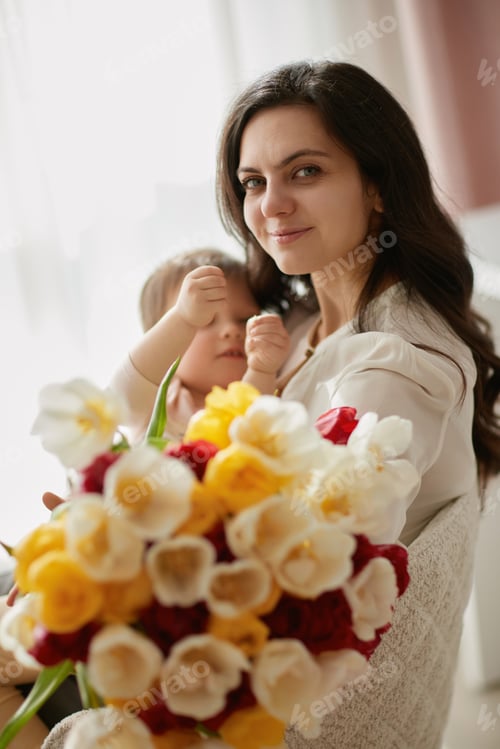 Preview: Cute little baby daughter and mom with flowers tulips.