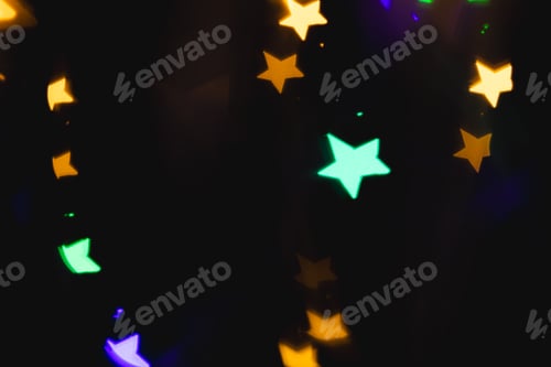 Preview: Multicoloured star bokeh lights with copy space on dark background