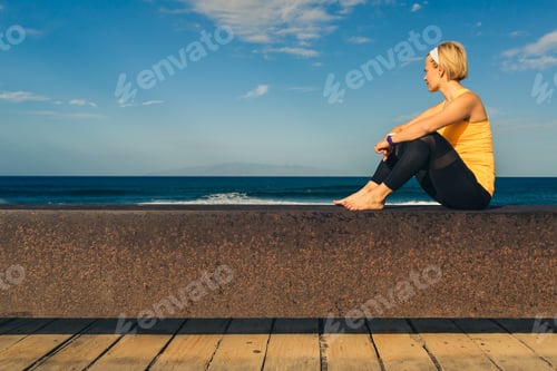 Preview: Yoga girl meditating and relaxing in yoga pose, ocean view