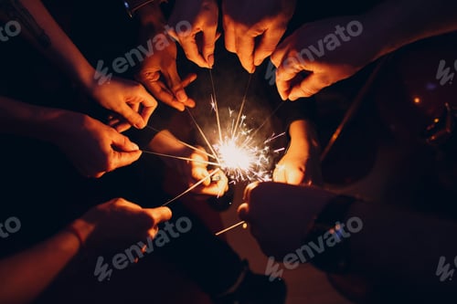 Preview: People set fire sparklers at party. Top view hands close up