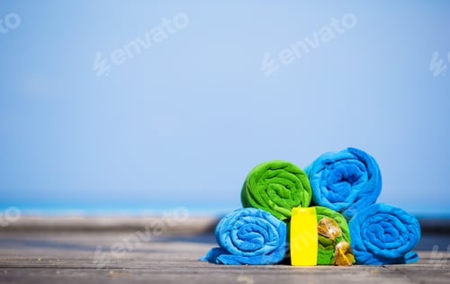 Preview: Beach and summer vacation accessories concept - close-up of colorful towels, swimming goggles and