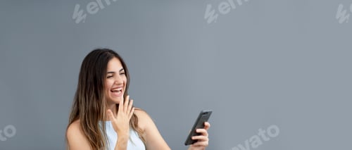 Preview: Cheerful Woman Smiling, Waving, and Using Smartphone