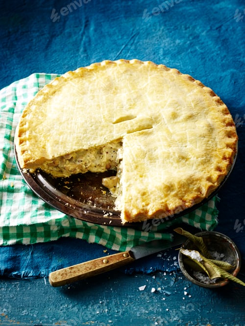 Preview: Freshly baked pie with a slice cut out on a blue background.