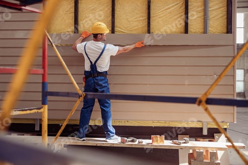 Preview: Male worker building cabin at construction site