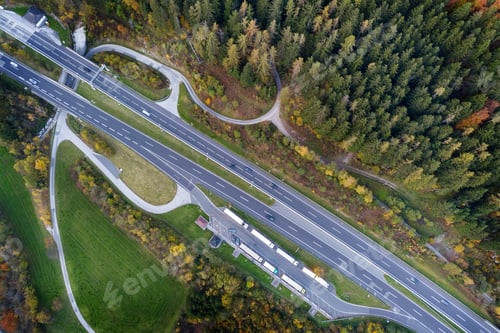 Preview: Top dawn aerial view of freeway speed road between yellow autumn forest trees in rural area.