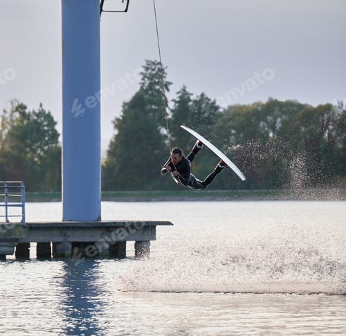 Preview: Young surfer having fun wakeboarding in the cable park.