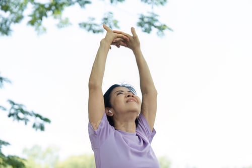 Preview: Wellness and Positivity. Woman enjoying the outdoors while stretching.