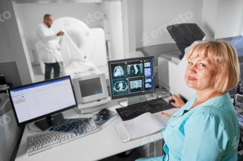 Preview: Female nurse sitting at computer, making MRI.