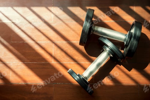 Preview: Fitness and healthy concept. Dumbbells on floor with shadow and light fron window in gym.