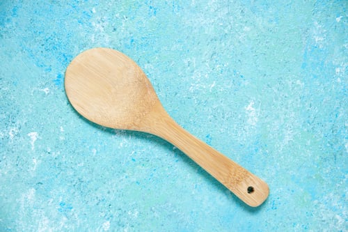 Preview: top view round wooden spoon on blue background with free space