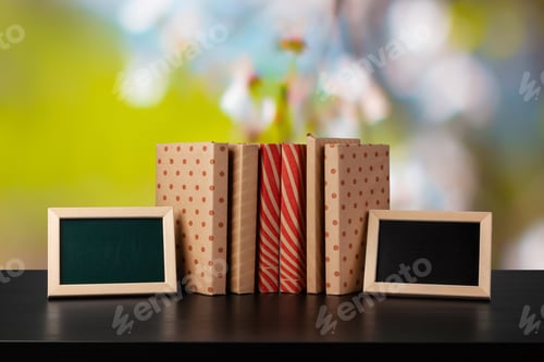 Preview: Stack of books on wooden table against blurred background