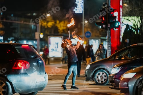 Preview: Street performer juggling fire at busy crosswalk