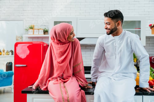 Preview: Happy middle eastern couple wearing traditional arab clothing at home