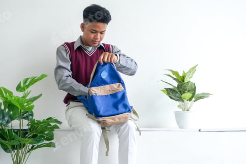 Preview: Young Asian Guy Wearing School Uniform Packing Backpack