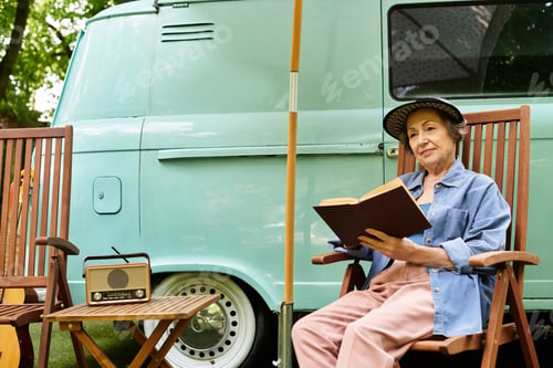Preview: Serene moments of a senior woman reading in a lush garden setting near a vintage van