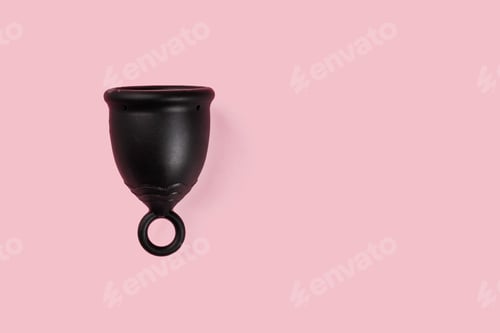 Preview: Black menstrual silicone cup on pink background