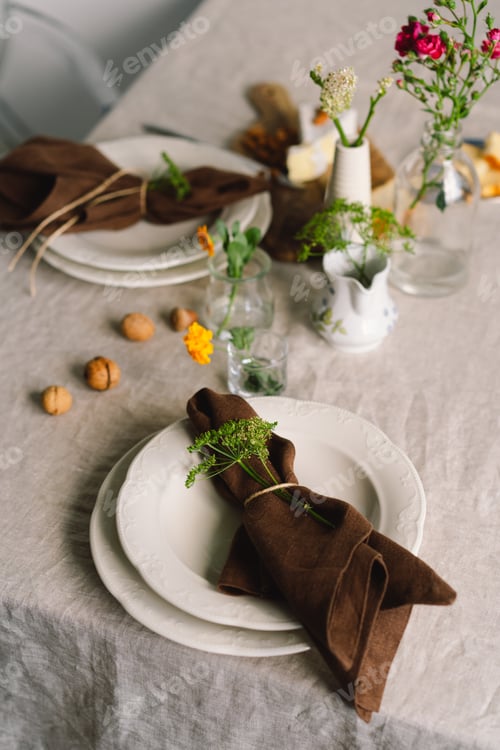 Preview: Vintage table setting with Linen napkins and floral decorations. Close up.