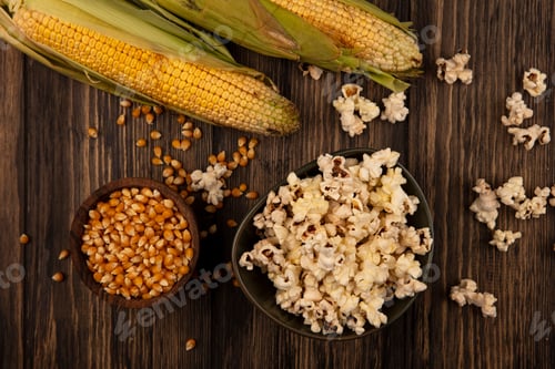 Preview: top view of a bowl of popcorns with corn kernels on a wooden bowl with fresh corns