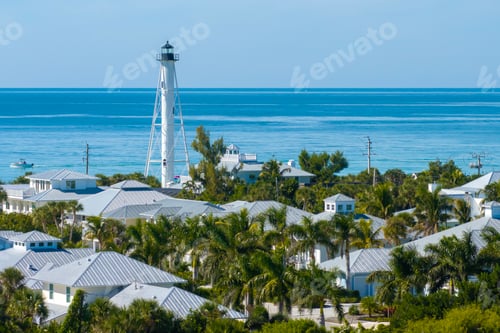 Preview: Expensive waterfront houses and white Boca Grande lighthouse on ocean shore.